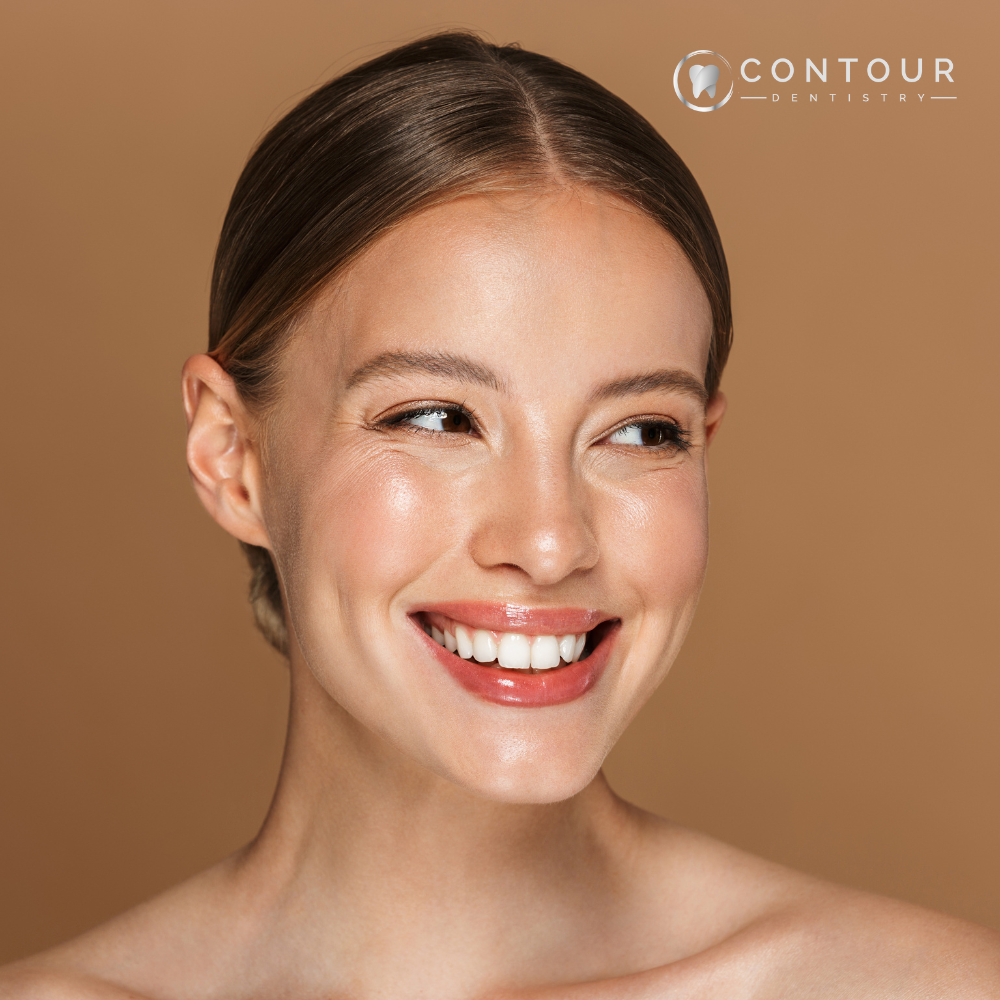Woman smiling in front of brown background with Contour Dentistry logo